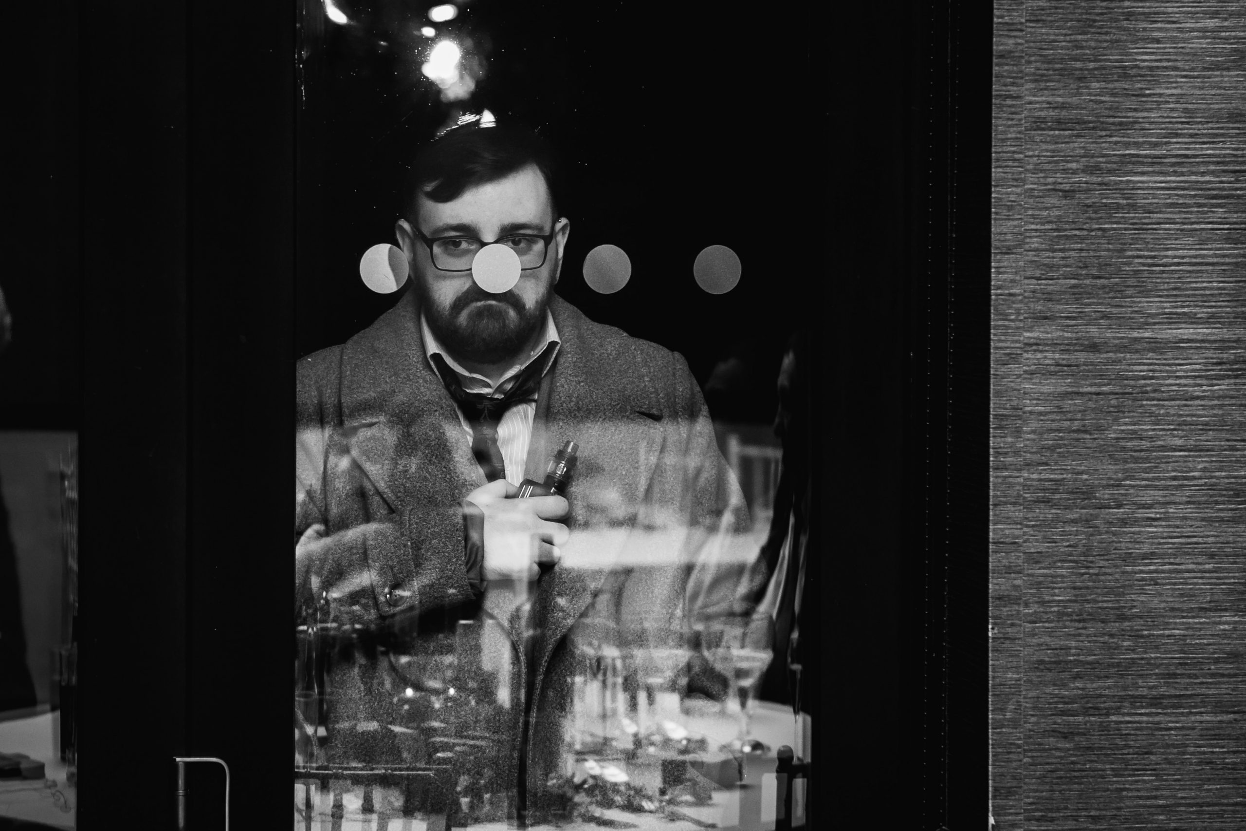 2022 A Year In Review 2022 A Year In Review - wedding guest standing outside in the cold smoking vape a dot on the window is positioned right over his nose
