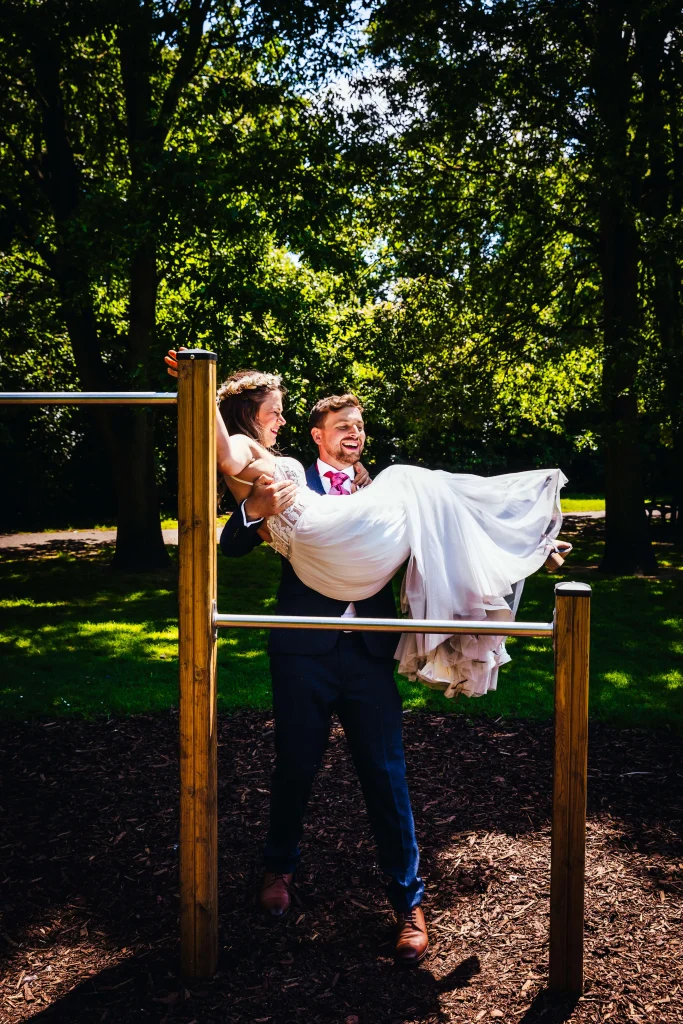 Couple playing on park on their wedding day