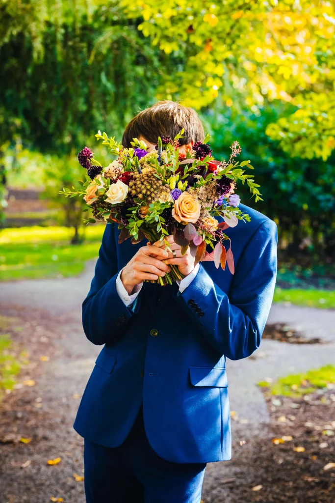 Wedding Photography Nottingham - Groom playfully hiding behind his new wifes bouquet