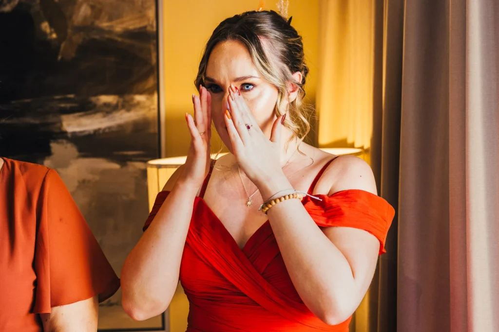 close up of bridesmaids emotional reaction to seeing her friend in her dress for the first time her eyes are beautifully blue.