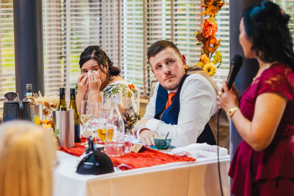 bride is dabbing her eyes with a tissue whilst she listens to her mums emotional speech