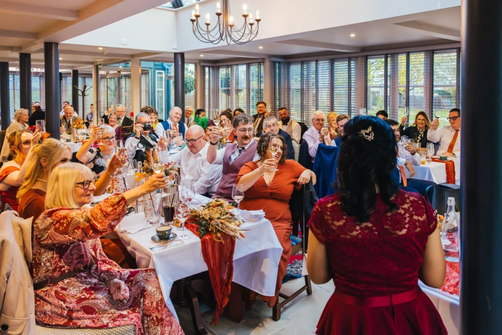 wedding guests are raising a glass to the happy couple at the end of speeches