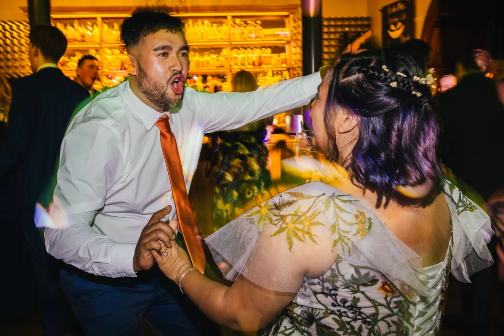 two people are dancing together whilst enthusiastically along to the song the DJ is playing