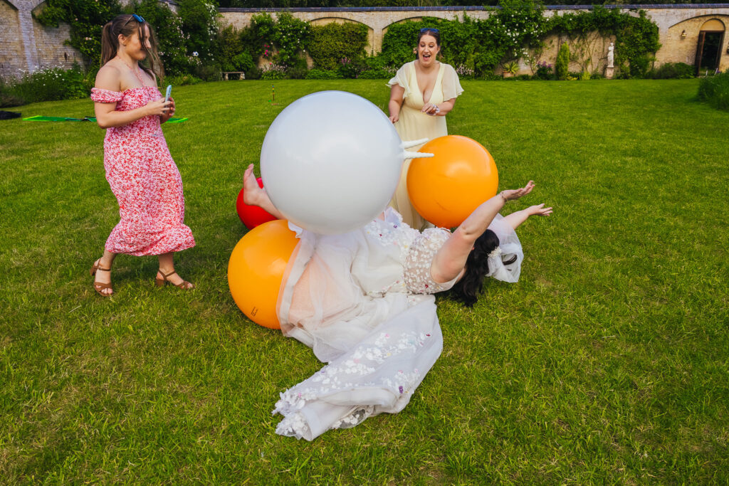 Bride laid on the floor after jumping into space hoppers guests are watching on laughing as one almost hits her in the face