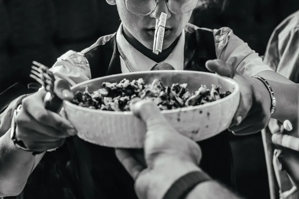 Guest with a personalised peg on their nose being offered a bowl of food